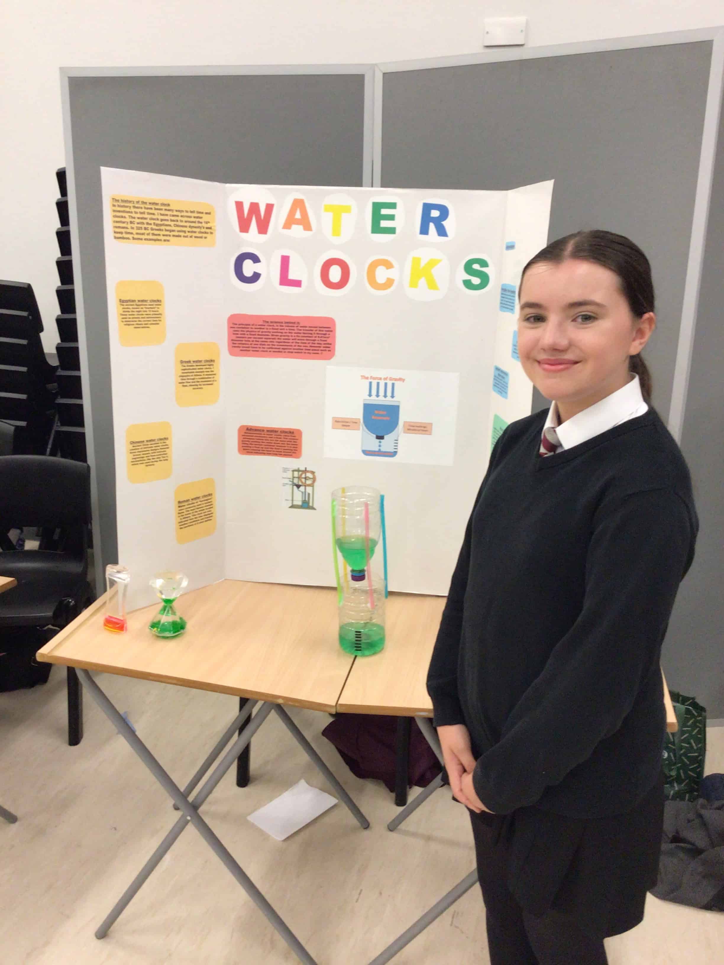 Emilia, Hazel Grove High School student poses with her Science project on Water Clocks.
