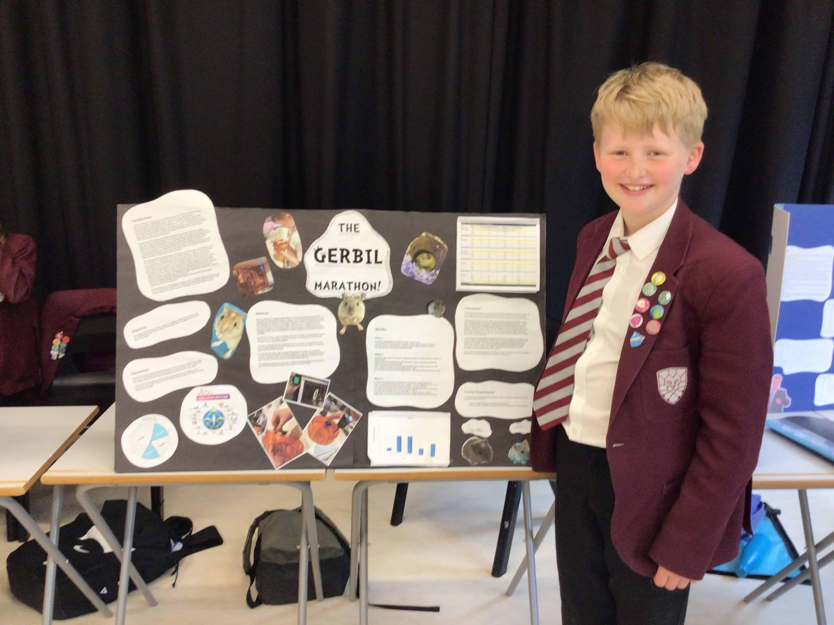 Will, a Hazel Grove High School student poses with his Science project, Gerbil Marathon.